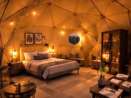 A dome bedroom under string lights, with a double bed and a round window.