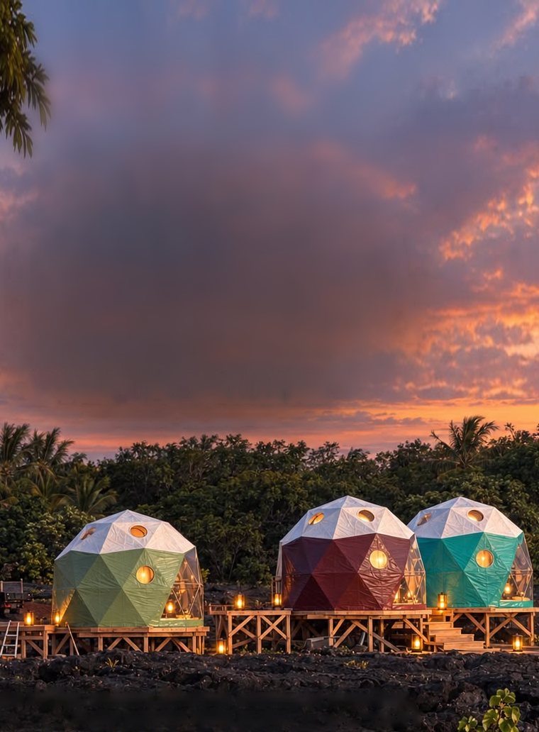 Three lantern-lit geodesic domes, green, maroon and teal, on raised platforms above a black lava field under a sunset sky.